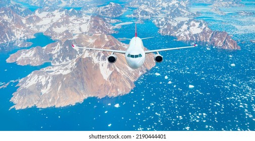 White Passenger Airplane In The Sky - View From Airplane Of Melting Polar Ice Cap And Snowy Mountains - Greenland