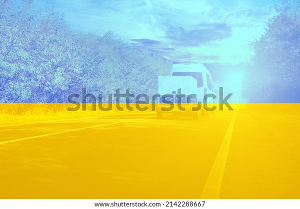 White passenger van\
with a small trailer on a countryside road with tees against a\
night sky with a sunset