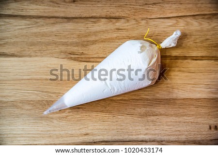 White pastry bag on wooden surface close