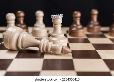 The white pawn in the crown with his team and the defeated white king.The concept of revolution, the fall of the dictatorial regime as a result of a coup, uprising, rebellion, coup d'etat