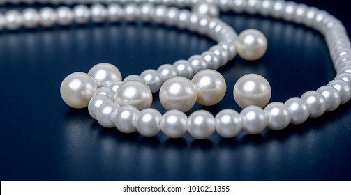 A White Pearl Necklace Before A Single Background