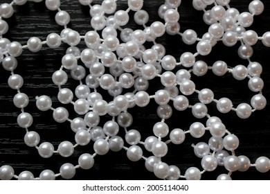 White Pearl Strings Isolated On Black Background.  Macro Close Up Of Fake Pearls With Blurred Background. Mardi Gras Beads Closeup.