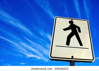 white pedestrian walking sign in the blue sky background