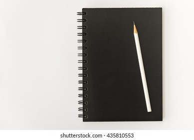 White Pencil With Black Notebook On White Background