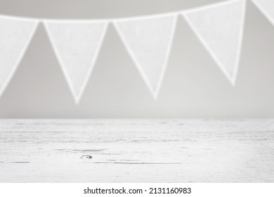 White Perspective Wooden Table Mockup With White Fabric Bunting Hanging In The Background.