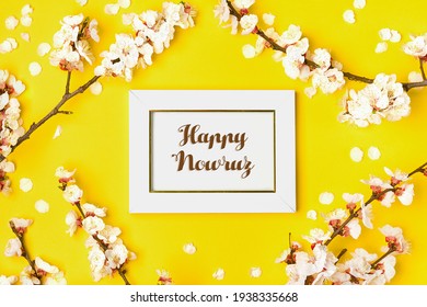 white photo frame and sprigs of the apricot tree with flowers on yellow background Text Happy Nowruz Concept of spring came Top view Flat lay Hello march, april, may, persian new year
