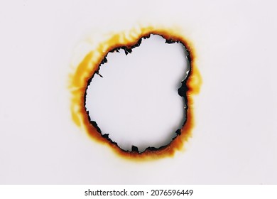 White photo paper has a burnt hole in the center.