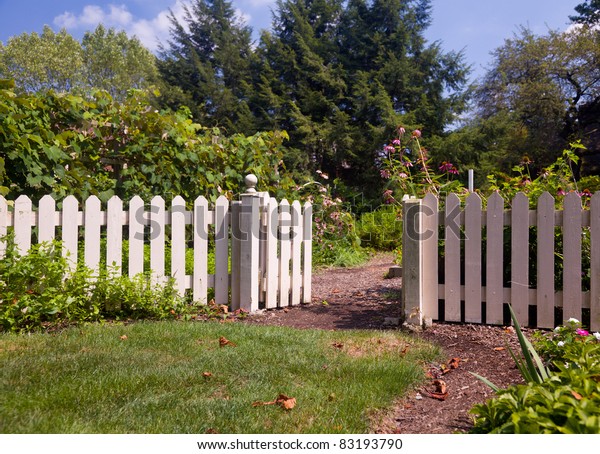 stock photo of the entrance to a small vegetable or market garden behind a white picket fence