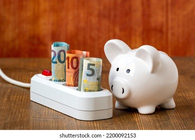 White piggy bank and electric extension cord with Euro currency. Concept of energy savings at home, utility bills, smart energy consumption - Powered by Shutterstock