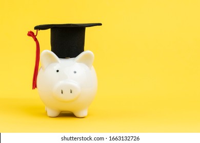 White Piggy Bank Wearing Graduation Cap On Yellow Background With Copy Space, Education Fund, Scholarship Or Savings For Study University And College Concept.