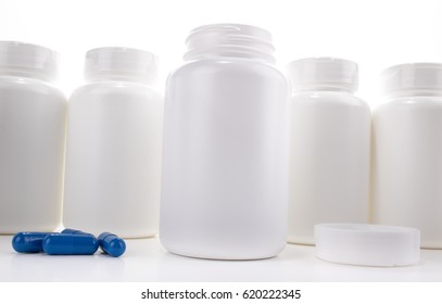 White Pill Bottle Open On Counter Between Cap And Blue Pills