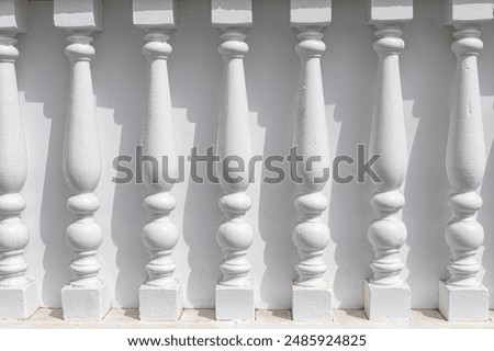 White pillars are part of a building facade. Decorative pillars made of wooden in a row