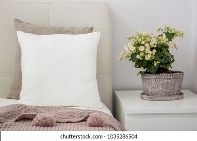 White pillow on bed in a cozy bedroom, Mockup