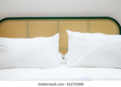 The White Pillow On A White Luxury Bed With Rattan Headboard.