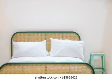 The White Pillow On A White Luxury Bed With Rattan Headboard.