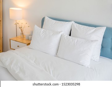 White Pillows, Duvet And Duvet Case On A Blue Bed. White Bed Linen On A Blue Sofa. Bedroom With Bed And Bedding. Right Side View.