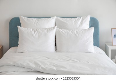 White Pillows, Duvet And Duvet Case On A Blue Bed. White Bed Linen On A Blue Sofa. Bedroom With Bed And Bedding. Front View.