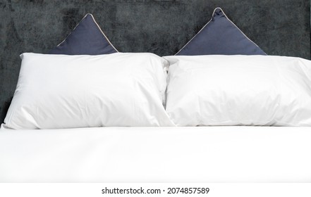 The White Pillows On The Bed Have A Velvet Headboard