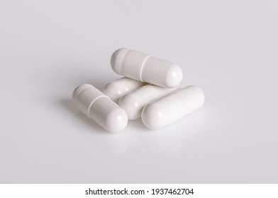 White pills capsules on white background.