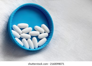 White pills close-up on a blue white background. close-up, pharmacovigilance, safety quality control