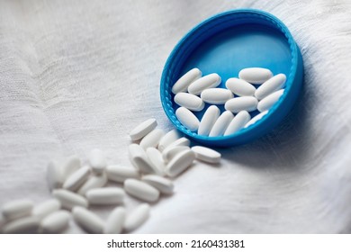 White pills close-up on a blue-white background. close-up, pharmacovigilance, safety quality control
