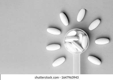 White Pills In Dosage Spoon For Drugs In The Shape Of A Flower On A Gray Background, Close-up. Top View, Flat Lay With Copy Space