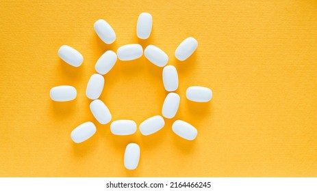 White pills on a yellow background. health care and medicine.	