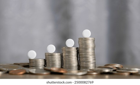 White pills are placed on a stack of coins used for disign health insurance, medical expenses and medicine, saving money, finance, saving money, business. financial and medical healthcare concept.