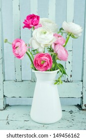 White and pink ranunculus flowers on light blue vintage chair