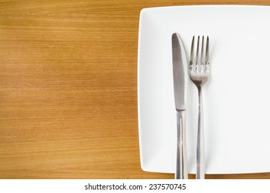 White Place Setting On A  Wooden Table