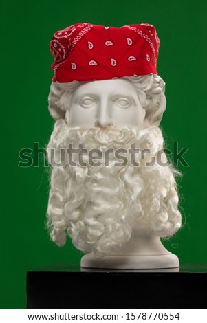 White plaster statue of a bust of Apollo Belvedere with a long white beard and a red bandana scarf