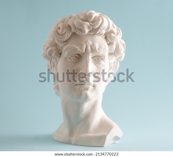 White plaster statue head of David on pastel blue\
background. Minimal art\
poster.