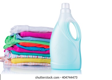 White Plastic Bottle Of Detergent And A Pile Of Clean Laundry On A White Background. Conditioner For Linen