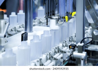 white plastic bottle moving on conveyor belt of auto capping and labeling machine at cosmetic and skin care manufacturing. cosmetic industry and ai technology machinery concept. - Powered by Shutterstock