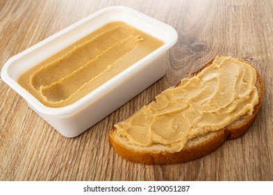 White Plastic Box With Sweet Peanut Paste, Sandwich With Peanut Butter On Wooden Table