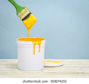 White Plastic Bucket With Yellow Color Paint And Brush On Wood,vintage Background