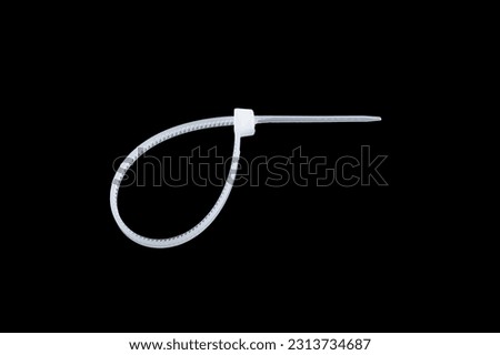 White plastic cable ties isolated on black background. plastic wire ties close-up.