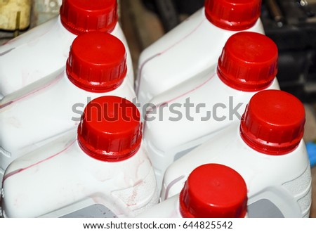 White plastic cans with red lids. Cans of transmission oil.