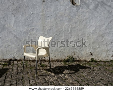 white plastic chair in front of old house facade, Teguise, Lanzarote, Canary Islands, Spain