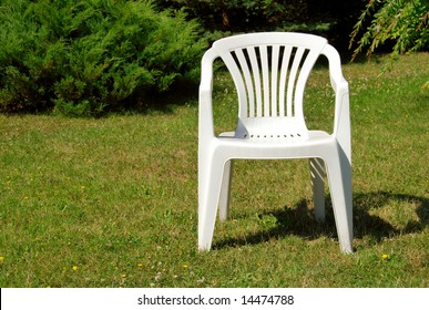 White Plastic Chair On The Grass In The Garden