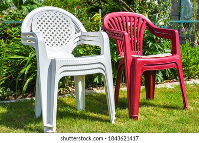 White Plastic Chair On Green Grass In Summer Garden