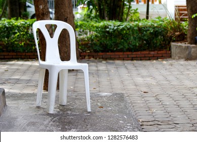 White Plastic Chair Under The Tree In The Garden