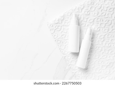 White plastic cosmetics bottles on a white cotton towel. Mockup cream, gel, tonic, cleanser, lotion and other professional cosmetics product presentation. Concept of cleanliness and freshness. - Shutterstock ID 2267750503
