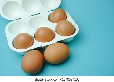 White Plastic Egg Tray With Eggs On Blue Background                  