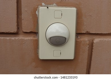 The White Plastic Electric Buzzer On Brown Brick Wall