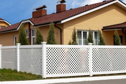 White Plastic Fence Around The House In A Modern Cottage Village. Concept Of Landscaping, Protection, Fencing Of The Territory.