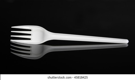 White Plastic Fork On A Black Reflecting Surface