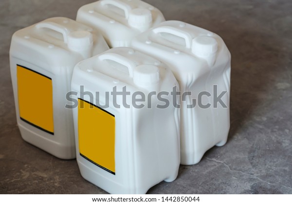 White plastic gallons with yellow blank\
label. White canstras on gray\
background.