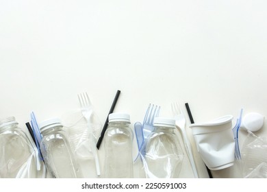 White plastic garbage on a white background. The concept of plastic recycling and ecology. Plastic waste, cutlery. Flat lay, top view