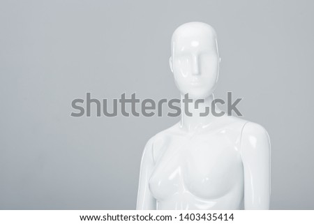 white plastic mannequin figure isolated on grey with copy space